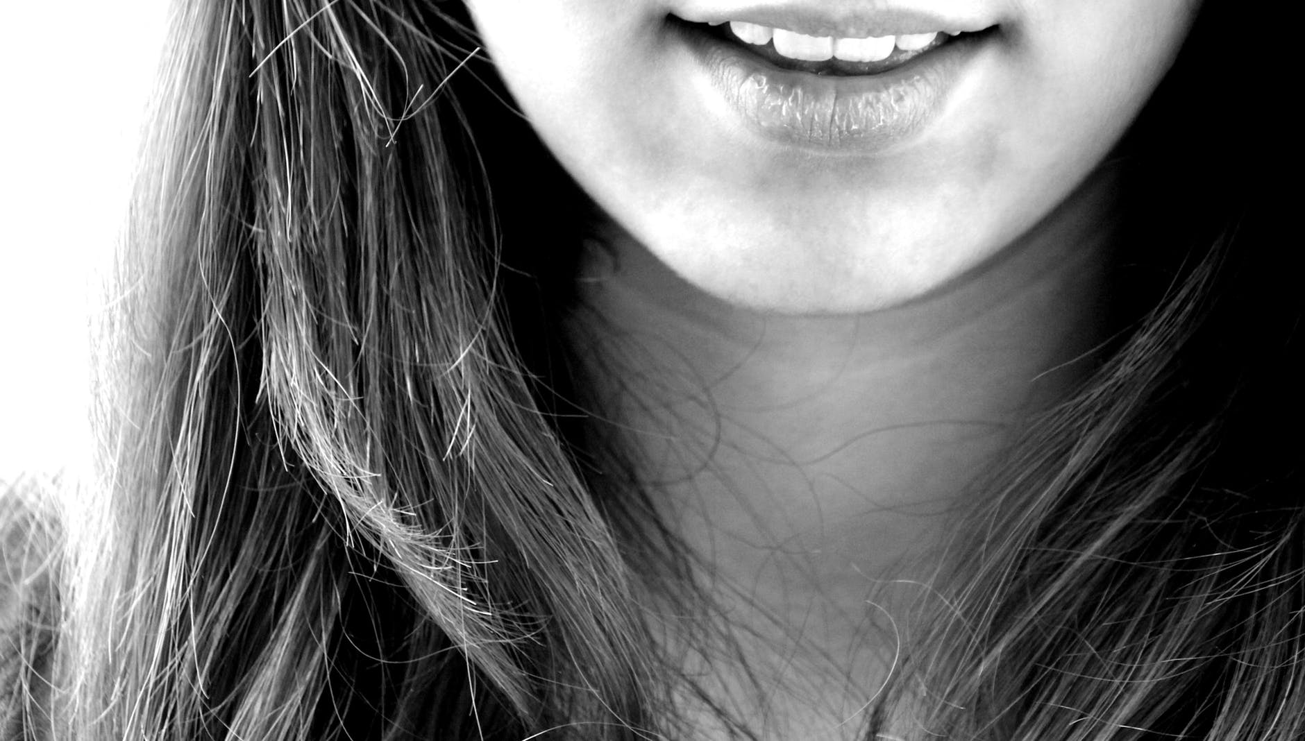 woman smiling in grayscale photography